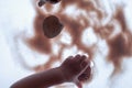 BabyÃ¢â¬â¢s hand, sand and seashells on light table. Royalty Free Stock Photo